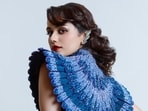 The actor looks breathtaking in a Nature-inspired ensemble featuring a drape gown with peacock feather motifs, adorned with sequins, and enhanded with structured shoulders, and cut out details at the waist. Her look is further elevated by Zambian emerald cascade diamond ear cuffs and statement diamond earrings.