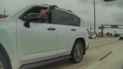 A driver in a grey Lexus pointing a firearm at a Tesla Cybertruck. (X/TaraBull) A driver in a grey Lexus pointing a firearm at a Tesla Cybertruck. (X/TaraBull)