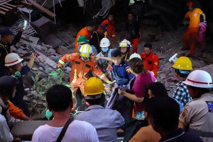 Rescue personnel carry a person out from the rubble of the building that collapsed following a strong earthquake, in Mandalay, Myanmar, March 29. (REUTERS)