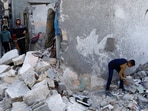 Palestinians inspect the site of an Israeli strike on a house in Gaza
