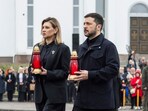 Ukraine's President Volodymyr Zelenskyy, right, and his wife Olena Zelenska carry candles to honour the memory of the victims of the Russian occupation at a memorial in the town of Bucha.