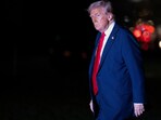 US President Donald Trump walks across the South Lawn while returning to the White House in Washington on March 30