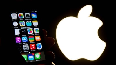 An illustration of an iPhone held up in front of the Apple Inc. logo taken of January 30, 2015 in Lille. Apple was fined �150 million on March 31, 2025 for abuse of a dominant position in the targeting of advertising on its devices, announced the French Competition Authority, while similar investigations are targeting the company in other European countries. (Philippe Huguen/AFP) An illustration of an iPhone held up in front of the Apple Inc. logo taken of January 30, 2015 in Lille. Apple was fined �150 million on March 31, 2025 for abuse of a dominant position in the targeting of advertising on its devices, announced the French Competition Authority, while similar investigations are targeting the company in other European countries. (Philippe Huguen/AFP)
