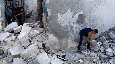Palestinians inspect the site of an Israeli strike on a house in Gaza (REUTERS)