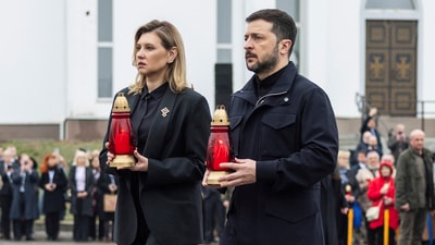 Ukraine's President Volodymyr Zelenskyy, right, and his wife Olena Zelenska carry candles to honour the memory of the victims of the Russian occupation at a memorial in the town of Bucha. (AP) Ukraine's President Volodymyr Zelenskyy, right, and his wife Olena Zelenska carry candles to honour the memory of the victims of the Russian occupation at a memorial in the town of Bucha. (AP)
