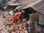 A rescuer works through rubble of a collapsed building following the earthquake in Myanmar A rescuer works through rubble of a collapsed building following the earthquake in Myanmar