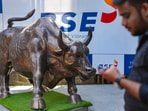 A man walks past the bull statue at BSE building in Mumbai.(PTI)