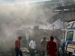 People gather at the site after a blast at a firecracker warehouse led to a blaze and collapse of the building, in Gujarat's Banaskantha district on April 1, 2025. 