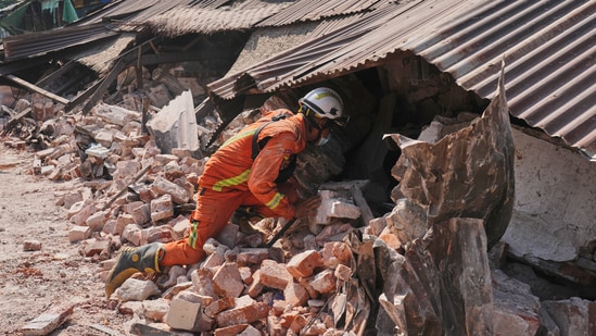A rescuer works through rubble of a collapsed building following the earthquake in Myanmar (AP)