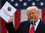 US President Donald Trump holds a "Foreign Trade Barriers" document as he delivers remarks on tariffs in the Rose Garden at the White House in Washington DC on April 2, 2025.