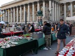 A person walks through a market in front of the former Paris Bourse, as global markets brace for a hit to trade and growth caused by U.S. President Donald Trump's decision to impose import tariffs on dozens of countries, in Paris, France.