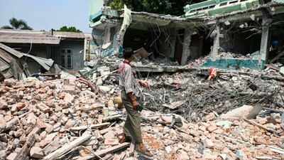 A man stands on the ruins of a hotel where survivor Tin Maung Htwe was extracted in Sagaing on April 3, 2025, following the March 28 earthquake. (AFP) A man stands on the ruins of a hotel where survivor Tin Maung Htwe was extracted in Sagaing on April 3, 2025, following the March 28 earthquake. (AFP)