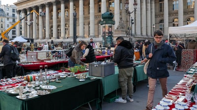 A person walks through a market in front of the former Paris Bourse, as global markets brace for a hit to trade and growth caused by U.S. President Donald Trump's decision to impose import tariffs on dozens of countries, in Paris, France. (REUTERS)