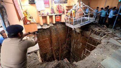 A police officer takes pictures during rescue operations after the roof of a stepwell in a temple complex collapsed in Indore on 30 March 2023. (Reuters) A police officer takes pictures during rescue operations after the roof of a stepwell in a temple complex collapsed in Indore on 30 March 2023. (Reuters)