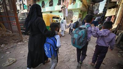 A woman escorts her three children to school. (Sanchit Khanna/HT Photo) A woman escorts her three children to school. (Sanchit Khanna/HT Photo)