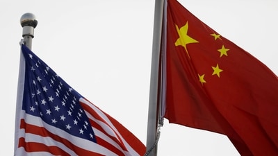 Chinese and US flags flutter outside the building of an American company in Beijing, (Reuters)