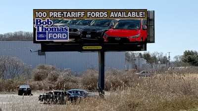 A sign advertising Ford vehicles for sale before any potential tariffs take effect stands by the side of a highway in North Haven, Connecticut, U.S. April 1, 2025.  Mel Yu/Handout via REUTERS. (via REUTERS)