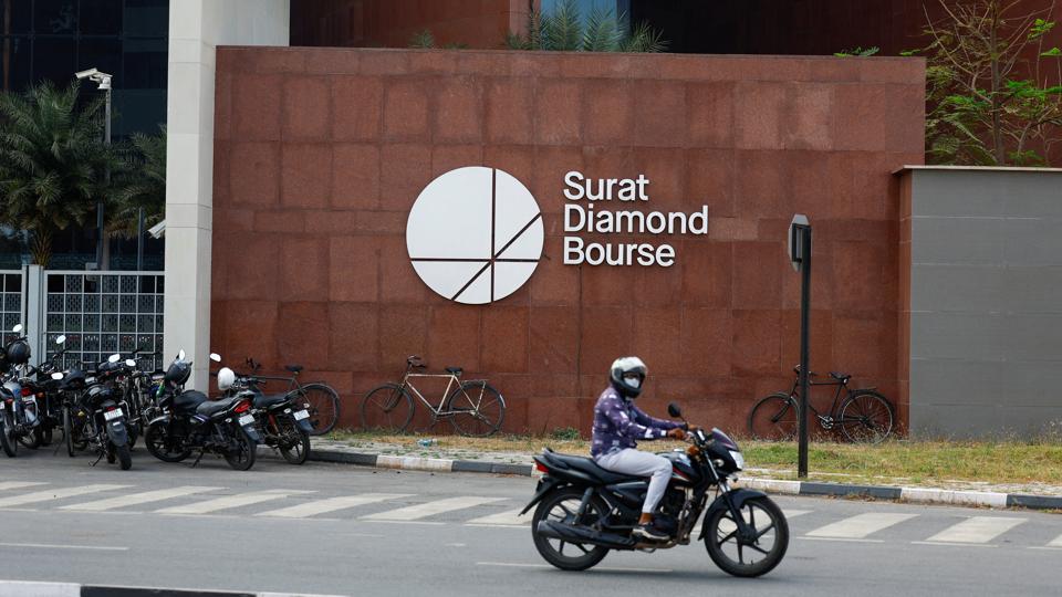 A man on a motorbike rides past the Surat Diamond Bourse (SDB), a diamond trade centre located in Diamond Research and Mercantile City, also known as DREAM City, in Surat (REUTERS) A man on a motorbike rides past the Surat Diamond Bourse (SDB), a diamond trade centre located in Diamond Research and Mercantile City, also known as DREAM City, in Surat (REUTERS)