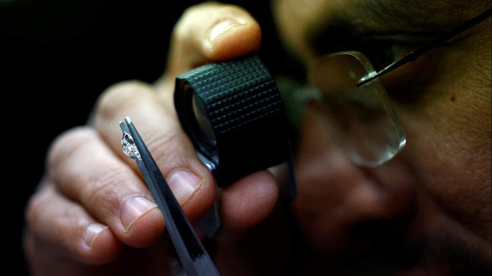 A craftsman checks the grading of a polished diamond in the grading department of a diamond processing unit in Surat (REUTERS) A craftsman checks the grading of a polished diamond in the grading department of a diamond processing unit in Surat (REUTERS)