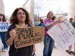 Amy Zeno, left, joins the Hands Off Our Schools rally outside the Department of Education building, Friday, April 4, 2025, in Washington. (AP Photo/Manuel Balce Ceneta) Amy Zeno, left, joins the Hands Off Our Schools rally outside the Department of Education building, Friday, April 4, 2025, in Washington. (AP Photo/Manuel Balce Ceneta)