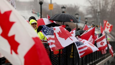 People hold flags as they protest in solidarity with Canada amid uncertainty over tariffs policy, near the Canada-US border crossing in Buffalo, New York (REUTERS)