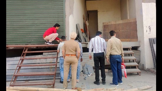Civic body staff seals the illegal building in Gandhi Nagar, Ludhiana, on Sunday. (HT Photo)