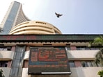 A bird flies past a screen displaying the Sensex results on the facade of the Bombay Stock Exchange (BSE) building in Mumbai.