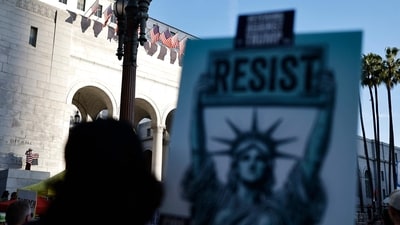 A protester waves an inverted American flag (L), known as a symbol of distress, at City Hall during a 'Hands Off!' protest against the Trump administration on April 5, 2025 in Los Angeles, California. Protests against Trump administration policies and Elon Musk's Department of Government Efficiency (DOGE) are being held nationwide in what organizers are calling a National Day of Action. (Getty Images via AFP) A protester waves an inverted American flag (L), known as a symbol of distress, at City Hall during a 'Hands Off!' protest against the Trump administration on April 5, 2025 in Los Angeles, California. Protests against Trump administration policies and Elon Musk's Department of Government Efficiency (DOGE) are being held nationwide in what organizers are calling a National Day of Action. (Getty Images via AFP)