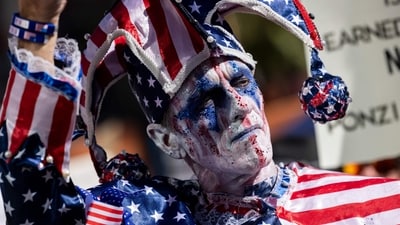 A protester dressed as a jester with his face painted in the colors of the US flag looks on during the nationwide "Hands Off!" protest against US President Donald Trump and his advisor, Tesla CEO Elon Musk, in downtown Los Angeles on April 5, 2025. (AFP) A protester dressed as a jester with his face painted in the colors of the US flag looks on during the nationwide "Hands Off!" protest against US President Donald Trump and his advisor, Tesla CEO Elon Musk, in downtown Los Angeles on April 5, 2025. (AFP)
