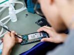A smartphone repair technician works on a Samsung Electronics' Galaxy S8 in Saint-Sebastien-sur-Loire