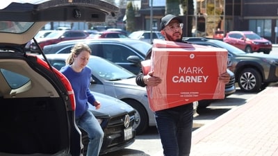 Volunteers unload signs at Liberal Party of Canada leader Mark Carney's campaign headquarters in the Nepean electoral district on April 1, 2025, in Ottawa, Canada, ahead of the 2025 Canada election (Photo by Dave Chan / AFP) (AFP)