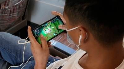 A man plays an online game from Chinese gaming platform Tencent on a train. (AP) A man plays an online game from Chinese gaming platform Tencent on a train. (AP)