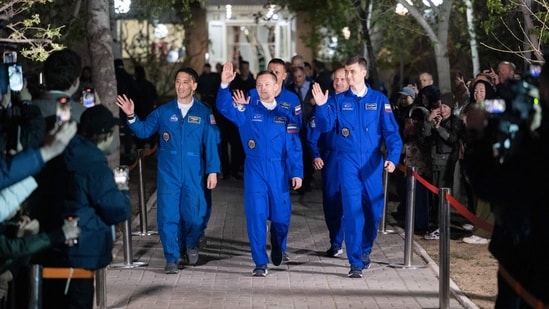The crew including members of the 73rd long-term expedition Roscosmos cosmonauts Sergey Ryzhikov (C), Alexey Zubritskiy (R) and US NASA astronaut Jonathan Yong "Jonny" Kim (L) wave goodbyes before the Soyuz MS-27 space craft blasts off the launch pad at the Russian-leased Baikonur cosmodrome in Kazakhstan to the International Space Station (ISS). (AFP)