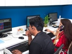 Brokers of a Rajasthan-based financial services provider react as they watch the stock prices on a digital screen, in Bikaner on Monday. 