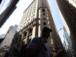 Pedestrians walk along Wall Street near the New York Stock Exchange (NYSE) in New York, US.