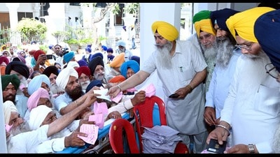 Sikh pilgrims collect their passports from a Shiromani Gurdwara Parbandhak Committee (SGPC) officials in Amritsar on Wednesday. (HT) Sikh pilgrims collect their passports from a Shiromani Gurdwara Parbandhak Committee (SGPC) officials in Amritsar on Wednesday. (HT)