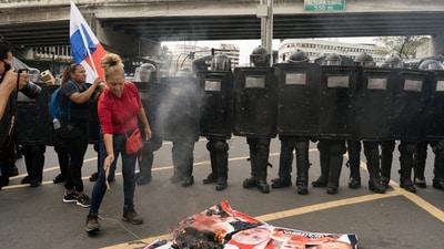A demonstrator stood over a burning poster with images of Hegseth, Trump, and Panama's President Jose Raul Mulino, during a protest against Hegseth's visit to Panama. REUTERS/Maria Fernanda Gonzalez (REUTERS)