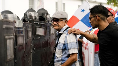 A demonstrator took a man away from a confrontation with police officers during a protest against Pete Hegseth's visit to Panama. REUTERS/Maria Fernanda Gonzalez (REUTERS)