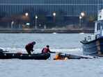 Emergency personnel work at the scene of a helicopter crash on the Hudson River near lower Manhattan in New York, as seen from Newport, New Jersey U.S., April 10, 2025. 