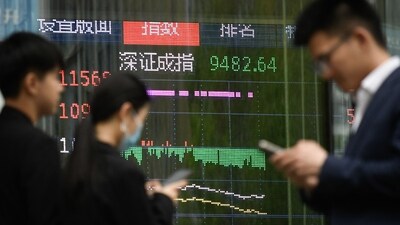 People walk past a screen showing Chinese stock market movements in Beijing on April 7, 2025. (AFP) People walk past a screen showing Chinese stock market movements in Beijing on April 7, 2025. (AFP)
