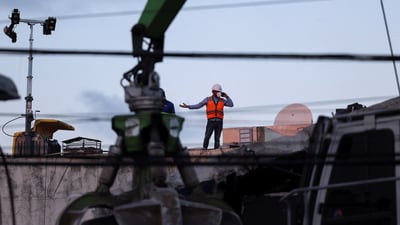 A man wearing vest and helmet gestures while using a cellphone during the recovery efforts at the site of the collapsed Jet Set nightclub in Santo Domingo, Dominican Republic, April 9, 2025. (Reuters)