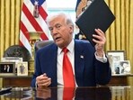 President Donald Trump holds an executive order in the Oval Office of the White House Wednesday, April 9, 2025, in Washington.
