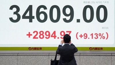 A man takes photos on an electronic board showing the closing numbers of the Nikkei Stock Average on the Tokyo Stock Exchange in Tokyo on April 10, 2025. (AFP) A man takes photos on an electronic board showing the closing numbers of the Nikkei Stock Average on the Tokyo Stock Exchange in Tokyo on April 10, 2025. (AFP)