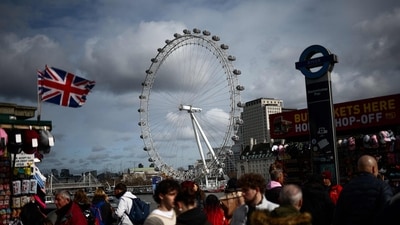 Pedestrians walk along Embankment backdropped by The London Eye, in London, on February 25, 2025. (AFP) Pedestrians walk along Embankment backdropped by The London Eye, in London, on February 25, 2025. (AFP)