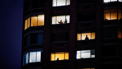 People look on from a building as emergency personnel work at the scene of a helicopter crash on the Hudson River near lower Manhattan in New York, as seen from Newport, New Jersey U.S., April 10, 2025.  REUTERS/Eduardo Munoz (REUTERS)