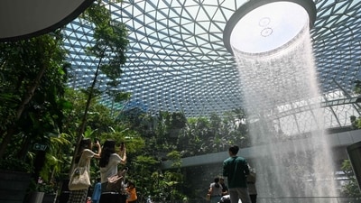 People take pictures of the Rain Vortex, the world's tallest indoor waterfall, at the Jewel complex at Singapore Changi Airport in Singapore on April 10, 2025. (Photo by Roslan RAHMAN / AFP) (AFP) People take pictures of the Rain Vortex, the world's tallest indoor waterfall, at the Jewel complex at Singapore Changi Airport in Singapore on April 10, 2025. (Photo by Roslan RAHMAN / AFP) (AFP)