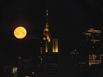The spring's first full moon, also known as "Pink Moon", is seen behind the headquarters of Commerzbank bank (C) in the banking district of Frankfurt am Main, western Germany on April 12, 2025.