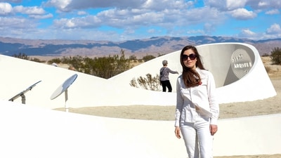 Sarah Meyohas poses in front of her piece “Truth Arrives in Slanted Beams,” (Photo by Valerie MACON / AFP) (AFP) Sarah Meyohas poses in front of her piece “Truth Arrives in Slanted Beams,” (Photo by Valerie MACON / AFP) (AFP)