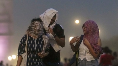 Visitors during a dust storm at the Kartavya Path, near India Gate, in New Delhi on Friday. (PTI) Visitors during a dust storm at the Kartavya Path, near India Gate, in New Delhi on Friday. (PTI)