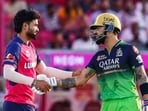 Kumar Kartikeya shakes hands with Virat Kohli.